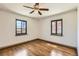 Bright bedroom featuring hardwood floors, ceiling fan, and two windows offering natural light at 1418 Glencoe St, Denver, CO 80220