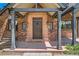 A welcoming entryway that features an attractive brick facade, a sturdy wooden door, and decorative exterior lighting at 1418 Glencoe St, Denver, CO 80220