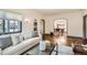 Bright living room featuring hardwood floors, neutral decor, and an open archway to dining at 1418 Glencoe St, Denver, CO 80220