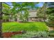 Spacious backyard with lush lawn, mature trees, a shed, and a cozy patio area at 1583 Sunset Ridge Rd, Highlands Ranch, CO 80126