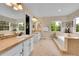Bright bathroom with double vanity, soaking tub, and tile flooring at 1583 Sunset Ridge Rd, Highlands Ranch, CO 80126