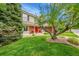 Charming two-story home with a brick facade, mature trees, and a well-manicured lawn at 1583 Sunset Ridge Rd, Highlands Ranch, CO 80126