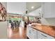 Kitchen and dining area with hardwood floors and a view into the living room with large windows at 1583 Sunset Ridge Rd, Highlands Ranch, CO 80126