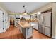 Spacious kitchen with white cabinets, stainless steel appliances, granite counters and a large center island at 1583 Sunset Ridge Rd, Highlands Ranch, CO 80126