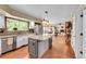 Open kitchen with white cabinets, stainless appliances, island, and adjacent dining area with backyard view at 1583 Sunset Ridge Rd, Highlands Ranch, CO 80126