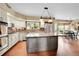 Open kitchen featuring a large island, stainless appliances, and brick backsplash at 1583 Sunset Ridge Rd, Highlands Ranch, CO 80126