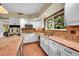 Updated kitchen featuring white cabinetry, brick backsplash, stainless steel appliances and granite countertops at 1583 Sunset Ridge Rd, Highlands Ranch, CO 80126