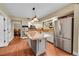 Spacious kitchen with stainless steel refrigerator and a large center island at 1583 Sunset Ridge Rd, Highlands Ranch, CO 80126