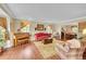 Comfortable living room featuring a piano, bay window, hardwood floors, and ample seating at 1583 Sunset Ridge Rd, Highlands Ranch, CO 80126