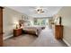 Spacious bedroom features large windows, a ceiling fan, tray ceiling and carpeted floor at 1583 Sunset Ridge Rd, Highlands Ranch, CO 80126