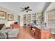 Home office with built-in bookshelves, hardwood floors, and a large desk at 1583 Sunset Ridge Rd, Highlands Ranch, CO 80126