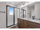 Modern bathroom featuring a glass-enclosed shower and a double vanity with marble counters at 16777 W 94Th Way, Arvada, CO 80007