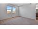 Sunlit bedroom with a window overlooking the neighborhood and beige carpeting at 16777 W 94Th Way, Arvada, CO 80007