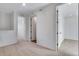 Hallway with tan carpet and white walls leading to open doorways and neutral-colored rooms at 16777 W 94Th Way, Arvada, CO 80007