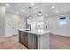 This kitchen island features stainless steel dishwasher, brown cabinets, white countertop, and modern fixtures at 16777 W 94Th Way, Arvada, CO 80007