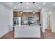 Modern kitchen featuring an island, stainless steel appliances, and dark wood cabinets and marbled backsplash at 16777 W 94Th Way, Arvada, CO 80007