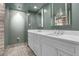 Modern bathroom with dual sinks, white cabinetry, framed mirrors, and tiled floor at 3131 E Alameda Ave # 1302, Denver, CO 80209