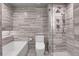 Beautiful bathroom featuring a tub and a shower with elegant gray textured tiling at 3131 E Alameda Ave # 1302, Denver, CO 80209