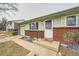 Welcoming front entrance with a covered porch, brick accents, and a charming front door at 14937 E Security Way, Aurora, CO 80011