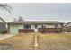 Charming ranch-style home with a brick facade, green paint, and a well-manicured front yard with rock path at 14937 E Security Way, Aurora, CO 80011