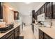 Spacious kitchen with dark wood cabinets, white appliances, and a view to a second room at 14937 E Security Way, Aurora, CO 80011