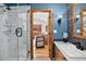 Stylish bathroom with glass shower, blue accent wall, and modern fixtures at 4241 S Meadow Brook Ln, Evergreen, CO 80439