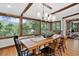 Dining room with views to the outdoors, exposed wood beams, and modern lighting at 4241 S Meadow Brook Ln, Evergreen, CO 80439