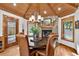 Charming dining room features a stone fireplace, wood ceiling, and unique chandelier at 4241 S Meadow Brook Ln, Evergreen, CO 80439
