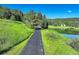 Picturesque driveway leading to a beautiful home with lush green surroundings and a serene pond view at 4241 S Meadow Brook Ln, Evergreen, CO 80439