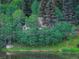 Secluded house surrounded by trees by the edge of the water at 4241 S Meadow Brook Ln, Evergreen, CO 80439
