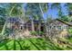 Beautiful multi-story home with stone accents, mature trees, and a well-manicured lawn at 4241 S Meadow Brook Ln, Evergreen, CO 80439