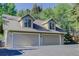 Exterior view of a spacious three-car garage with neutral color and architectural style at 4241 S Meadow Brook Ln, Evergreen, CO 80439