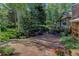A flagstone patio set amongst mature trees with a seating area provides a tranquil outdoor living space at 4241 S Meadow Brook Ln, Evergreen, CO 80439