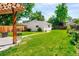 The backyard features a lush green lawn, a pergola, and a storage shed at 1856 S Monroe St, Denver, CO 80210