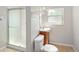 The bathroom features a glass-doored shower, tile flooring, a window, and updated fixtures at 1856 S Monroe St, Denver, CO 80210