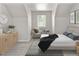 Stylishly staged bedroom features neutral colors, comfortable seating, and a calming atmosphere at 1856 S Monroe St, Denver, CO 80210