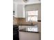 Close-up of a kitchen featuring white cabinets, granite countertops, and stainless steel appliances at 1856 S Monroe St, Denver, CO 80210