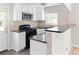 Updated kitchen with white cabinets, granite countertops, a breakfast bar, and stainless steel appliances at 1856 S Monroe St, Denver, CO 80210