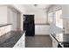 Well-lit kitchen featuring white cabinets, modern appliances, and sleek black granite countertops with mosaic backsplash at 1856 S Monroe St, Denver, CO 80210