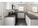 Well-lit kitchen featuring white cabinets, modern appliances, and sleek black granite countertops with mosaic backsplash at 1856 S Monroe St, Denver, CO 80210