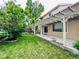 Exterior of home with a covered patio and a well maintained lawn at 6102 S Yampa St, Aurora, CO 80016