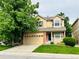 Inviting two-story home with a well-manicured lawn, mature shade tree, and attached two car garage at 6102 S Yampa St, Aurora, CO 80016