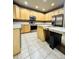 Bright kitchen featuring an island, tile floors, ample wood cabinetry and stainless steel appliances at 6102 S Yampa St, Aurora, CO 80016