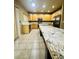 Spacious kitchen featuring a large island, tile flooring, stainless appliances, and wood cabinets at 6102 S Yampa St, Aurora, CO 80016