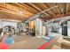 Partially finished basement with exposed ceiling and flooring partially covered by area rugs at 4710 N Foxtail Dr, Castle Rock, CO 80109