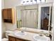 Bathroom featuring a double sink vanity, a large mirror, and a shower/tub combo at 4710 N Foxtail Dr, Castle Rock, CO 80109