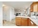 Bright kitchen with wooden cabinets, white appliances, and an open layout leading to other rooms at 4710 N Foxtail Dr, Castle Rock, CO 80109