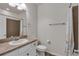Bathroom with granite vanity top, framed mirror, and neutral-colored tile in shower at 3678 Shadow Cir, Castle Rock, CO 80109