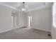 Spacious bedroom with tray ceiling and modern chandelier, carpeted floors, and entry to the bathroom at 3678 Shadow Cir, Castle Rock, CO 80109