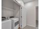 Convenient laundry room with modern washer and dryer units, shelving, and doorway at 3678 Shadow Cir, Castle Rock, CO 80109